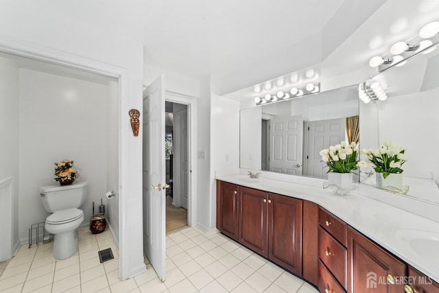 full bathroom with double vanity, baseboards, toilet, tile patterned flooring, and a sink