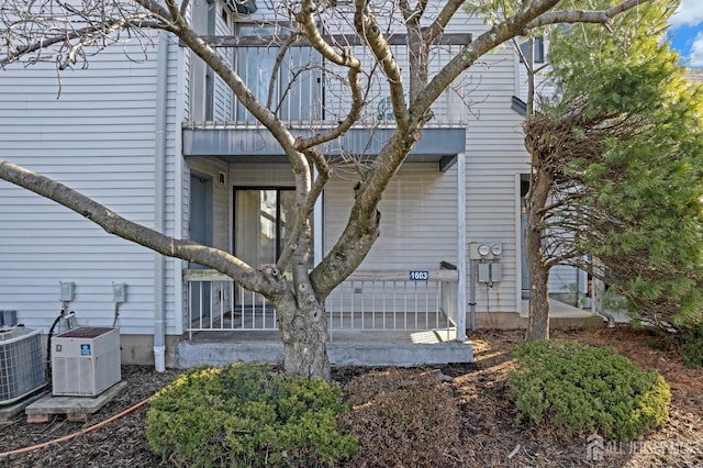 view of side of home featuring a balcony and central AC unit