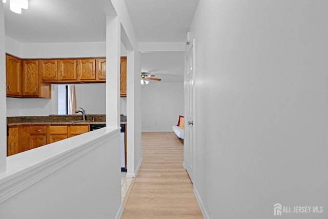 interior space featuring light wood-type flooring, a sink, and baseboards