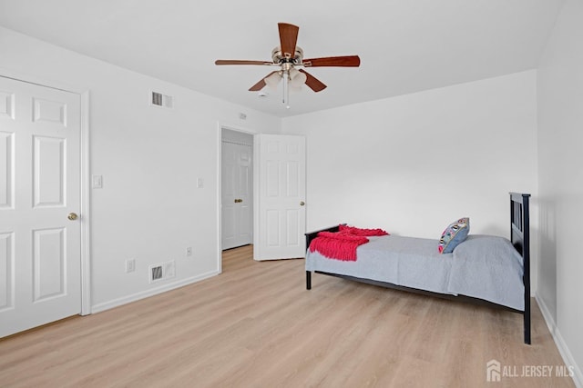 bedroom with light wood-type flooring, baseboards, and visible vents