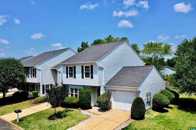 view of front of home with an attached garage, concrete driveway, a front yard, and a shingled roof