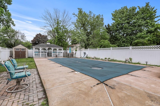 view of swimming pool with a patio, a storage shed, an outdoor structure, fence, and a gazebo