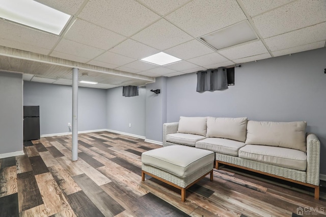 interior space featuring wood finished floors, a paneled ceiling, and baseboards