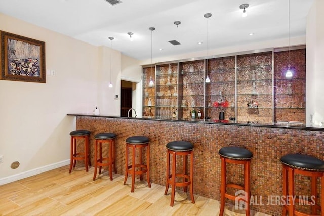 bar with sink, pendant lighting, and hardwood / wood-style flooring