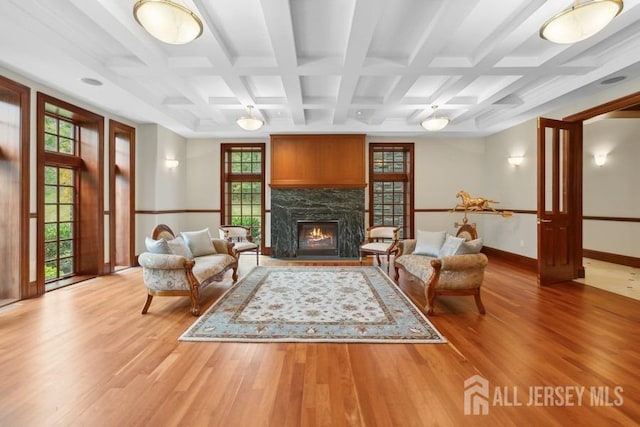 living room featuring a premium fireplace, beamed ceiling, hardwood / wood-style flooring, and coffered ceiling