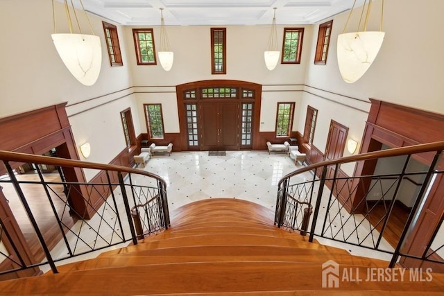 foyer with coffered ceiling, plenty of natural light, and beam ceiling