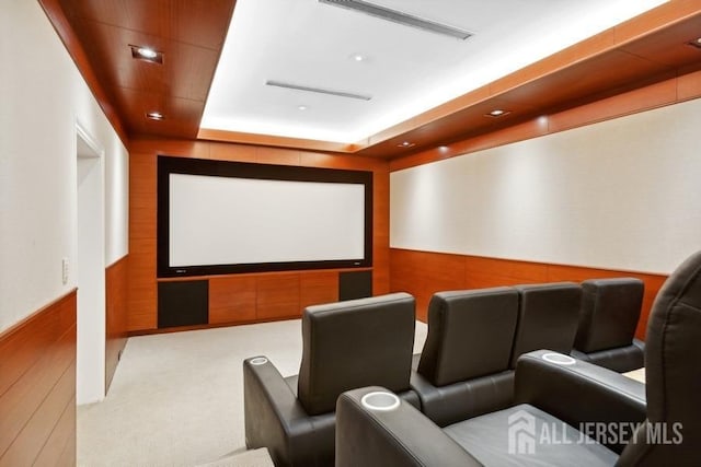 carpeted home theater featuring a tray ceiling