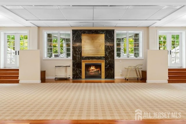 unfurnished sunroom with a paneled ceiling and a premium fireplace