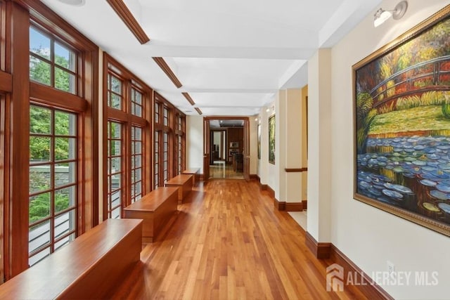 corridor with french doors, beamed ceiling, and light hardwood / wood-style flooring