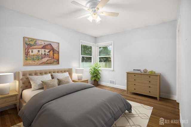 bedroom with baseboards, wood finished floors, visible vents, and a ceiling fan