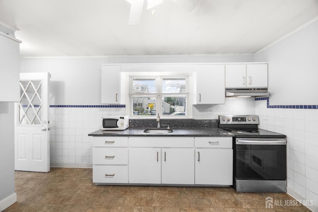 kitchen featuring tile walls, electric stove, under cabinet range hood, and a sink