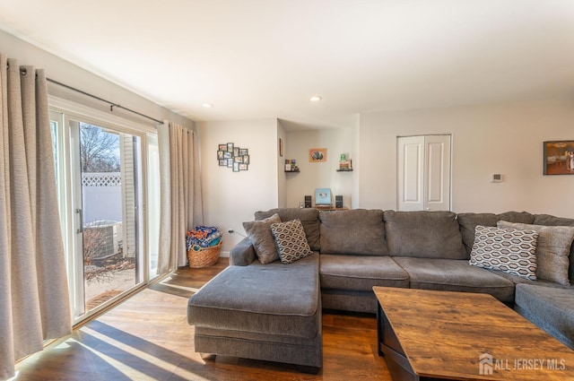 living room with recessed lighting and dark wood-type flooring