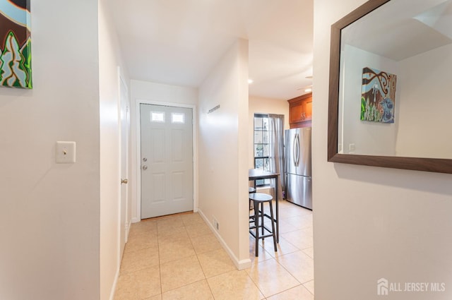 corridor with baseboards and light tile patterned flooring