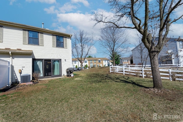 view of yard with central air condition unit and fence