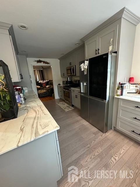 150 School St, Piscataway, NJ 08878 - kitchen with appliances with stainless steel finishes, light wood finished floors, light stone countertops, and gray cabinets