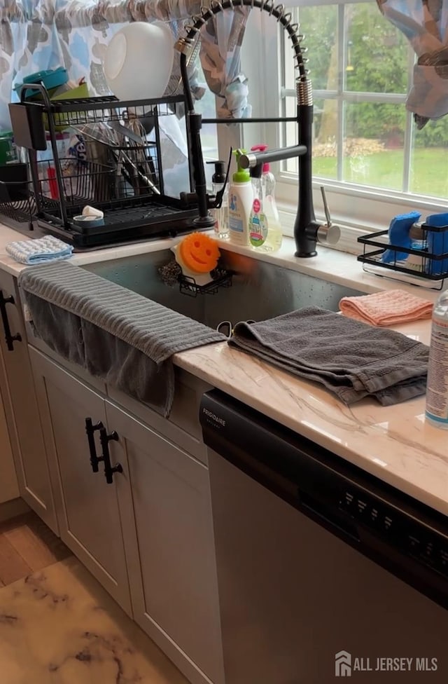 150 School St, Piscataway, NJ 08878 - kitchen view of stainless steel dishwasher, light stone countertops, and light wood finished floors