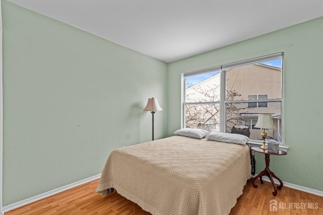 bedroom with baseboards and wood finished floors