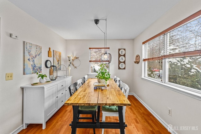 dining area featuring light wood-style flooring and baseboards