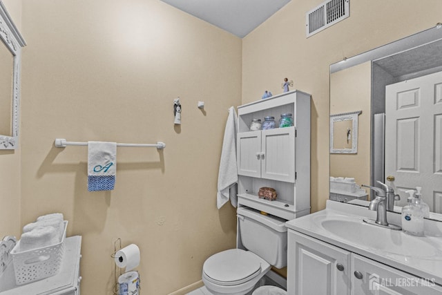 bathroom with baseboards, visible vents, vanity, and toilet