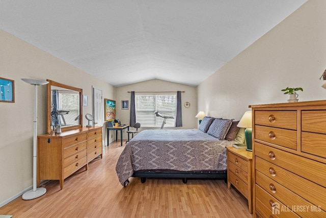 bedroom with vaulted ceiling and light wood-style flooring