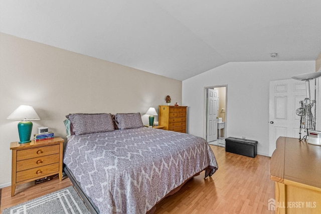 bedroom featuring lofted ceiling, baseboards, and wood finished floors