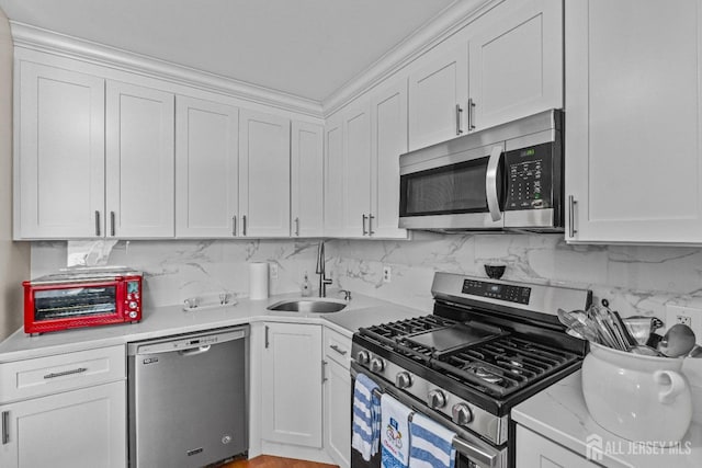 kitchen featuring stainless steel appliances, white cabinetry, and a sink