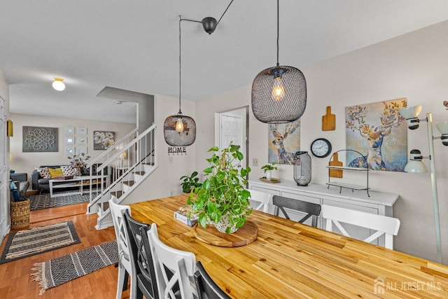 dining area with stairway and wood finished floors