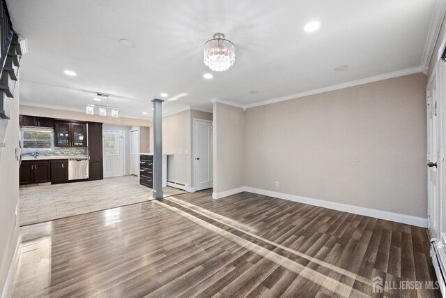 unfurnished living room featuring a baseboard radiator, dark hardwood / wood-style floors, crown molding, and a notable chandelier