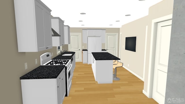 kitchen featuring under cabinet range hood, white range with gas stovetop, a breakfast bar, a sink, and dark countertops