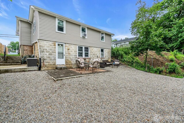 208 Hilltop Blvd, Old Bridge, NJ 07735 - rear view of house featuring stone siding, a patio, and cooling unit