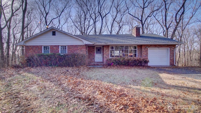 single story home featuring brick siding, a chimney, and an attached garage