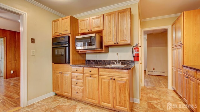 kitchen with a sink, black oven, stainless steel microwave, crown molding, and a baseboard radiator