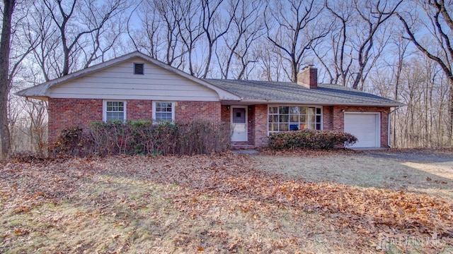 ranch-style home with an attached garage, brick siding, and a chimney