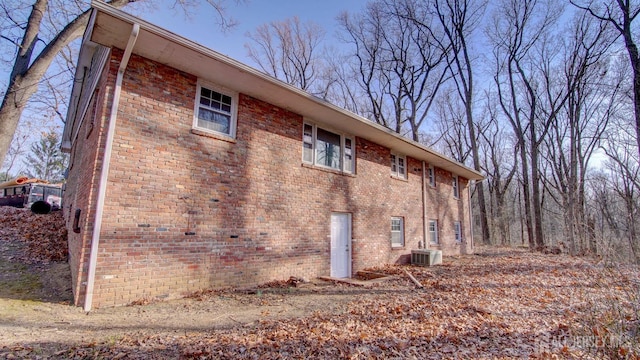 view of home's exterior featuring central air condition unit and brick siding