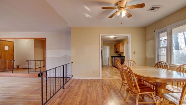 dining area with baseboards, visible vents, ceiling fan, light wood-type flooring, and baseboard heating