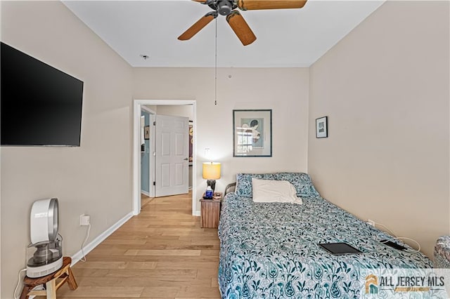 bedroom featuring light wood-style flooring, baseboards, and ceiling fan