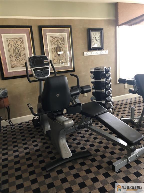 workout room with baseboards and carpet floors