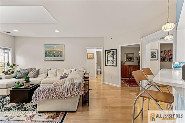 living room featuring light wood-style floors, recessed lighting, and baseboards
