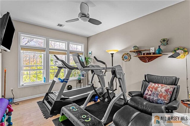 exercise room featuring baseboards, a ceiling fan, and wood finished floors