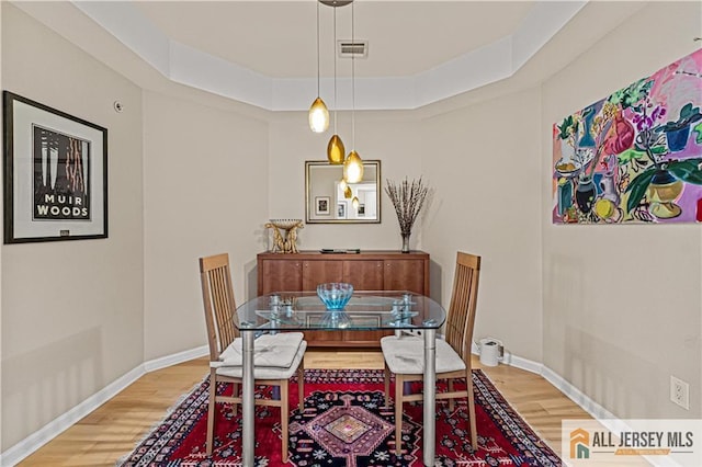 dining area featuring light wood finished floors and baseboards