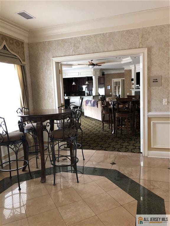 dining area with crown molding, ceiling fan, and tile patterned flooring