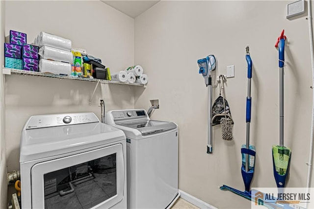 laundry room with washer and dryer and baseboards