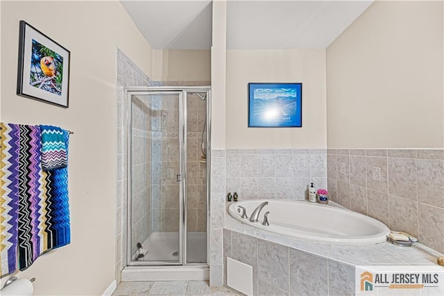 bathroom featuring a shower stall and a bath