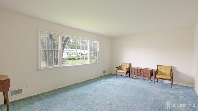 living area featuring carpet and baseboards