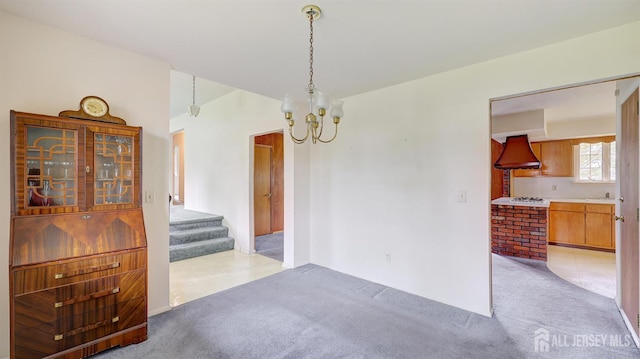 unfurnished dining area featuring light colored carpet, a chandelier, stairs, and a sink