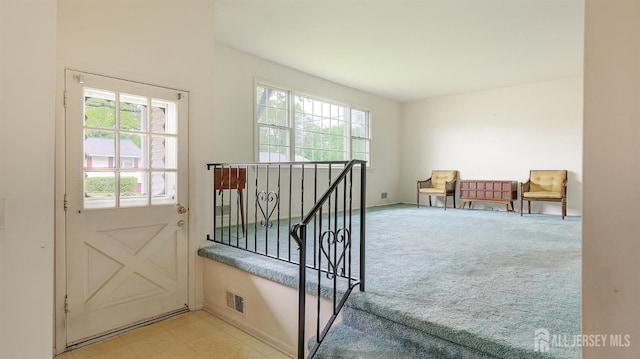 doorway featuring light colored carpet and baseboards