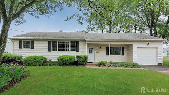 ranch-style home featuring a garage, a front lawn, driveway, covered porch, and a chimney