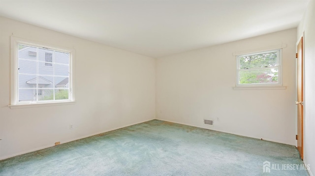 carpeted spare room featuring baseboards
