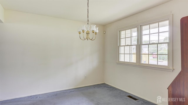 carpeted spare room featuring a chandelier and baseboards