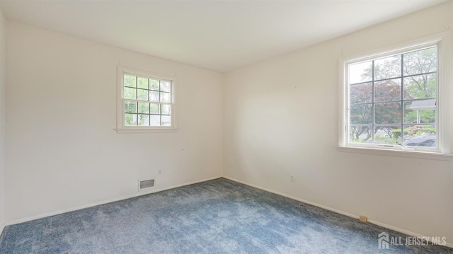 carpeted empty room featuring baseboards